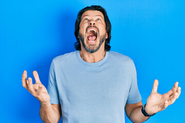 Middle age caucasian man wearing casual clothes crazy and mad shouting and yelling with aggressive expression and arms raised. frustration concept.