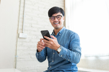 asian man work using cell phone hand holding mobile texting message contact us.chatting,search...