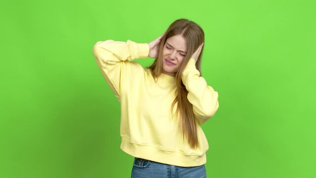 Teenager girl covering both ears with hands. Frustrated expression  over isolated background. Green screen chroma key