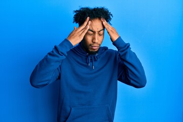 Young african american man with beard wearing casual sweatshirt with hand on head, headache because...