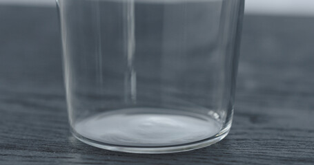 empty tumbler glass on black oak table