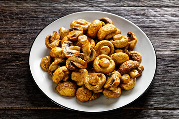 grilled juicy mushrooms on a plate, top view