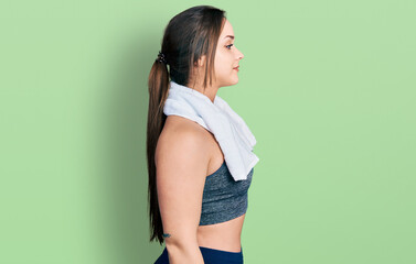 Young hispanic girl wearing sportswear and towel looking to side, relax profile pose with natural face and confident smile.