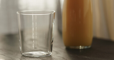 orange juice in glass bottle on black wood table with copy space