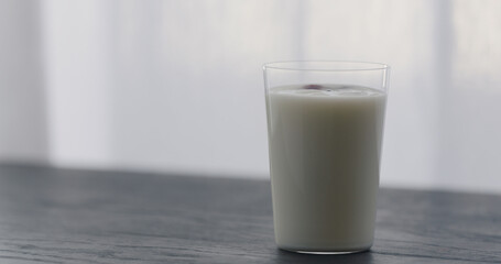 organic yogurt in tumbler glass on black wood table with copy space