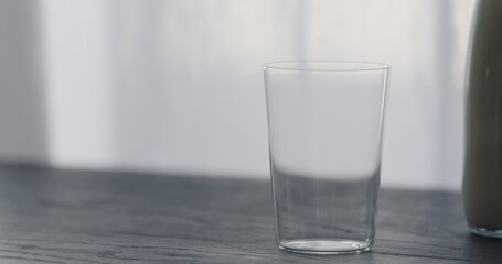 empty tumbler glass on black oak table
