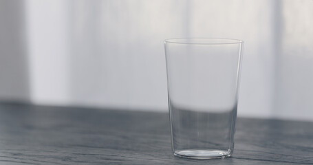 empty tumbler glass on black oak table