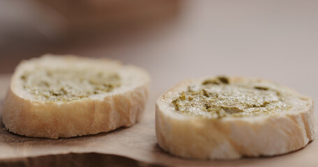pesto on fresh baguette slice to make sandwich closeup