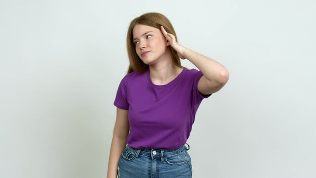 Teenager girl listening to something by putting hand on the ear over isolated background