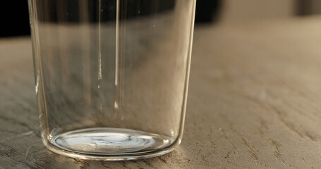 empty tumbler glass on black oak table