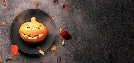halloween pumpkin on a black plate and a black background. scary burning eyes, a menu for a bar or...