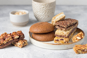 Energy cereal bars with nuts, seeds and dried fruits on gray table. Healthy vegan snack. closeup