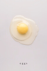 raw egg on a white background. top view. minimalistic food art, healthy food, vertical design photography