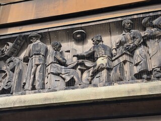 Obraz premium Building relief showing people of different occupations