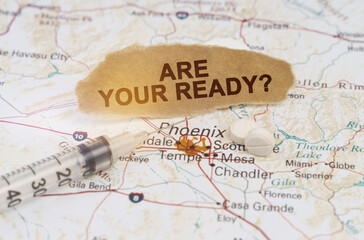 On the map of Arizona lies a syringe, pills and paper with the inscription - ARE YOUR READY