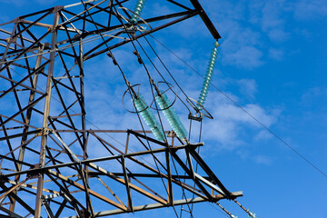 power line construction of cable supports and insulators. High voltage power line on blue sky background in Sunny day. Close-up