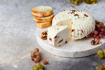 round homemade cheese with herbs and dried tomatoes