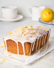 Delicious lemon bread with white icing and poppy seeds. Flowing glaze on pie with citrus peel. Tasty pastries for dessert. Sweet cake for tea. Homemade orange fruitcake with zest and frosting