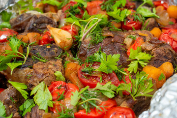 Close-up of delicious juicy meat baked in the oven with vegetables and decorated with fresh herbs. Food background