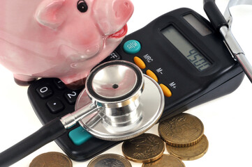 Concept de co&ucirc;t des soins avec une tirelire pos&eacute;e sur une calculatrice et des euros en gros plan sur fond blanc