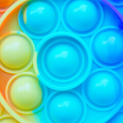 Pop it fidget. Colorful toy push pop it. Close up of anti stress sensory fidget. Trendy popular silicone colorful anti stress pop it toy . 
