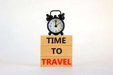 Time to travel symbol. Wooden blocks with concept words 'Time to travel'. Black alarm clock. Beautiful white background. Business and time to travel concept. Copy space.