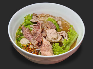 A Bowl of Spicy Soup with Beef and Meatballs Isolated on Gray