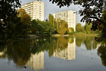 Lumière d'un soir d'automne à l'étang de la Pêcherie entouré de végétation luxuriant à proximité d'une cité à Auderghem 