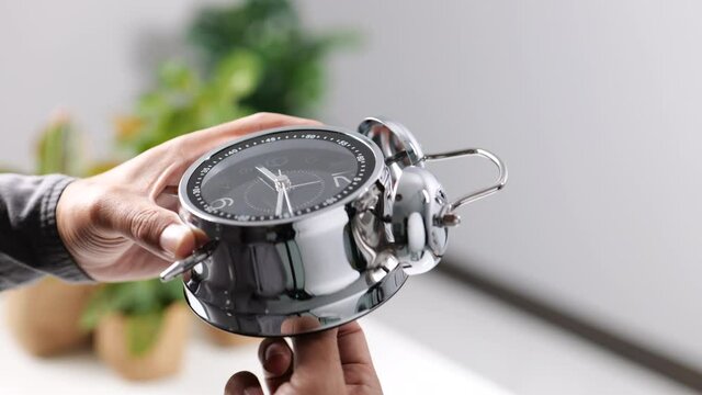 Time management concept. Male hand adjusting or changing the time on clock.
