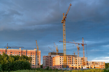 Lifting construction cranes, construction of brick residential multistory buildings against the...
