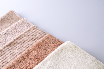 Fototapeta na wymiar Different cotton soft towels on a light background