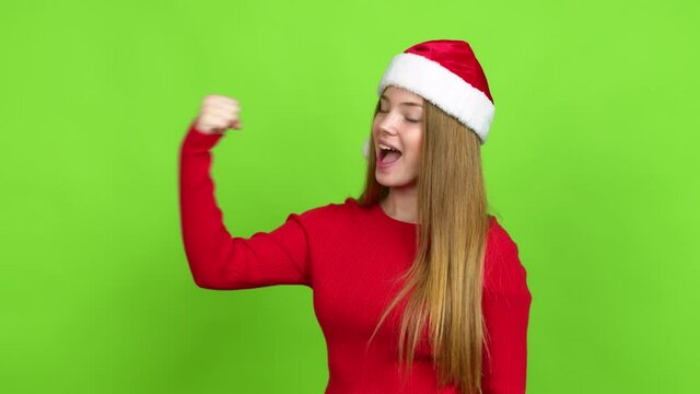 Teenager girl with christmas hat celebrating a victory over isolated background. Green screen chroma key