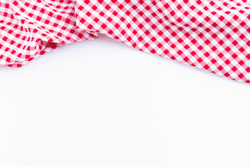 Checkers fabric crumpled top view with copy space. Red and white tablecloth on white background.