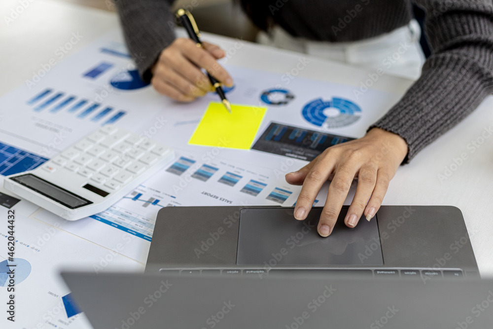 Wall mural A woman holding a sales summary, the sales manager is looking at the monthly sales summary document and summarizing it to pay the salesperson commissions. Sales management concept.