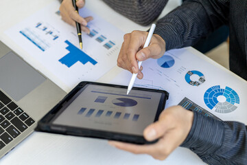 The atmosphere in the conference room was attended by two businessmen, a joint company operating brainstorming meeting for business growth, They are looking at data from the tablet.