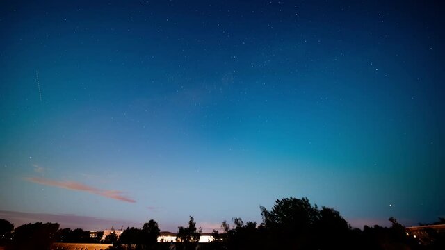 Time lapse sky with clouds and stars over the city day and night