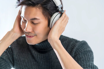 portrait studio music lyric concept yound smart asian artist wear  sweater listen headphone enjoy...