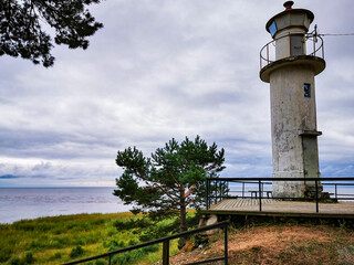 Old lighthouse standing by the sea on a cloudy day