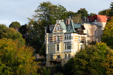 Fototapeta na wymiar Slow Travel Europe: Karlovy Vary (Karlsbad) in Czech Republic - beautiful town house among autumn colored trees on central hill