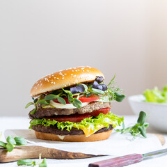 Double cheeseburger with veal cutlets, tomatoes, lettuce leaves and cucumbers. Fast food.