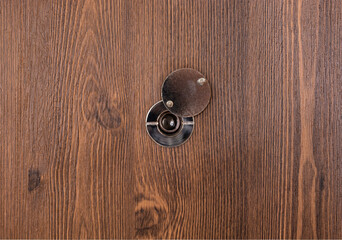 opening door peephole with a lens on a dark wooden texture