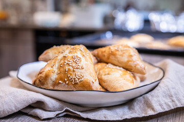 Puff pastry buns with pumpkin sprinkled with sesame seeds. Homemade autumn pastries.