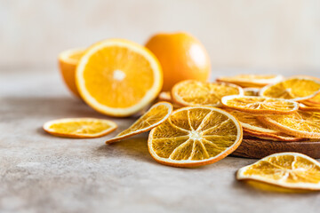 Natural dried oranges on light concrete background. Sliced and dried citrus fruit. Close up.
