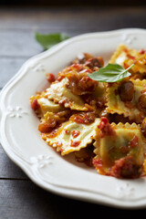 Ravioli with mushrooms and fresh basil. Dark wooden background. Close up