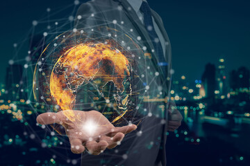 Double exposure of Businessman hand holding the particle earth with technology network circle over the photo blurred of cityscape background, technology and innovation concept
