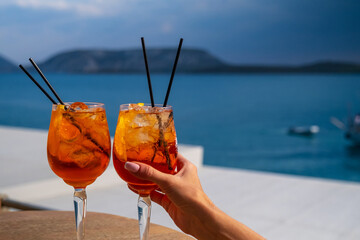 Orange drink or cocktail standing at the little table at the restaurant or cafe with sea background