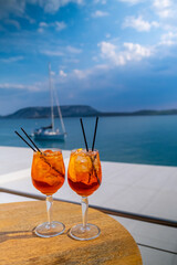 Orange drink or cocktail standing at the little table at the restaurant or cafe with sea background