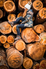 Woman sitting on logs cut for timber mill