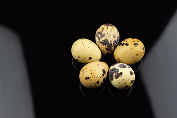 Close up of Quail eggs on black background.