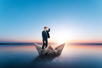 A businessman floats in a Paper Boat made of dollars banknotes. Origami from money, financial...